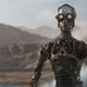 A droid without any plating or outside covering stares at the camera on a desert world.